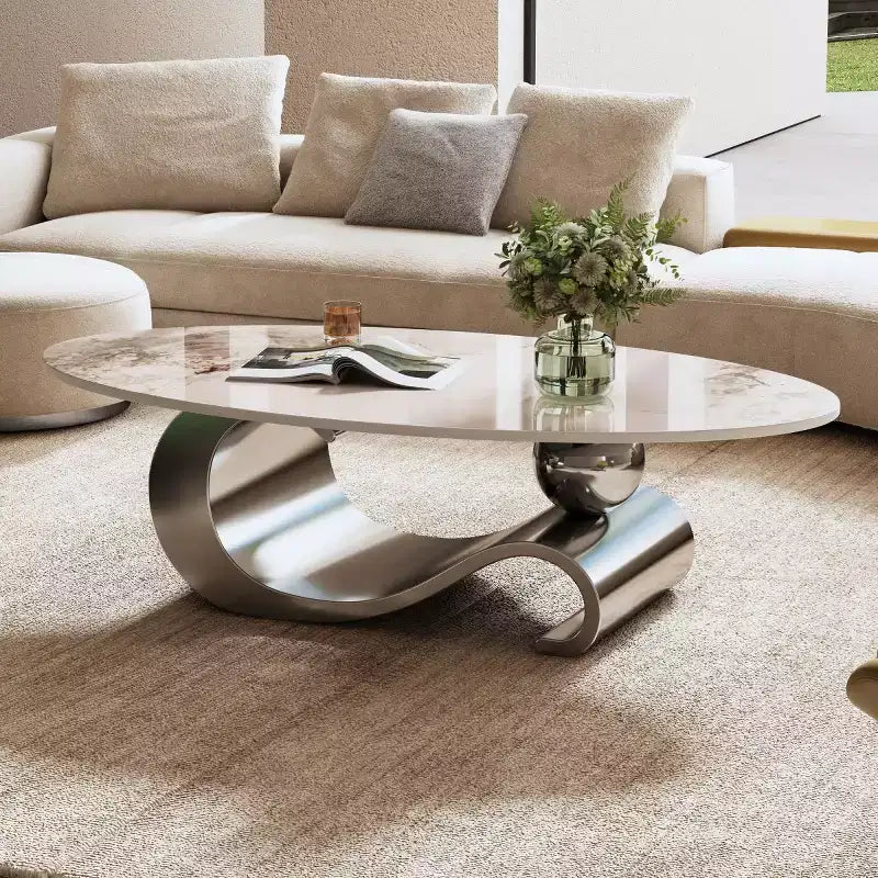 Table basse ovale de 124 cm avec plateau en pierre frittée imitation marbre et piètement sculptural en acier inoxydable