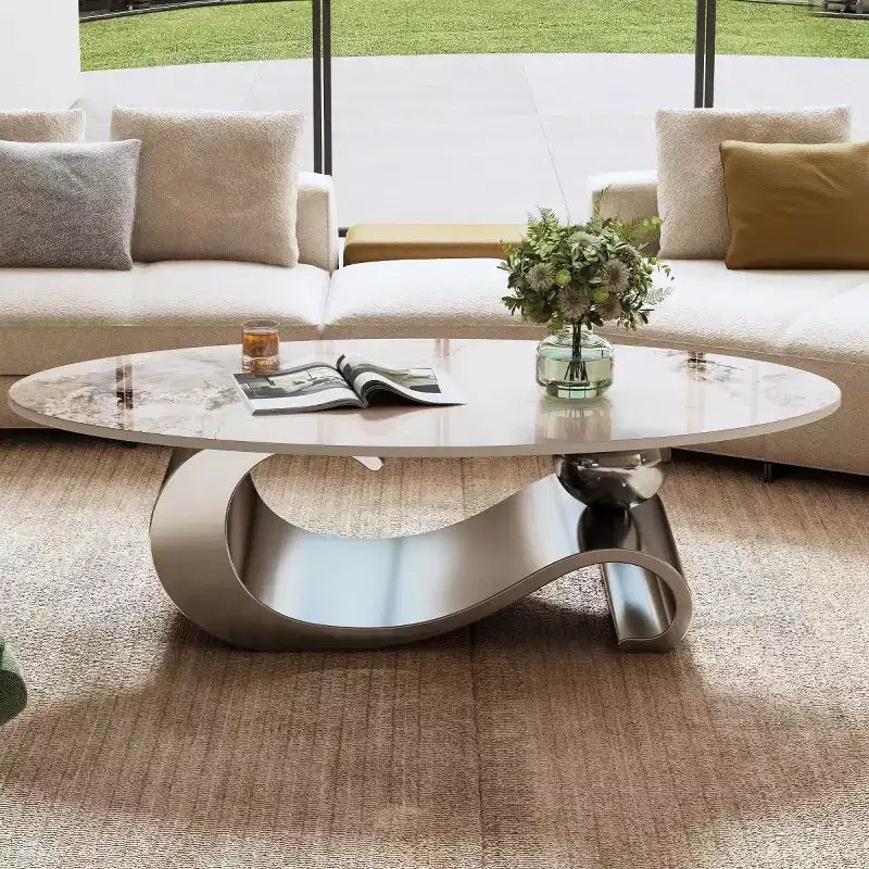 Table basse ovale de 124 cm avec plateau en pierre frittée imitation marbre et piètement sculptural en acier inoxydable